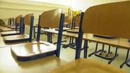 Ein leeres Klassenzimmer mit hochgestellten Stühlen © Screenshot 