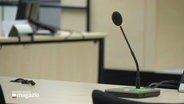 Ein Mikrofon in einem Gerichtssaal. © Screenshot 