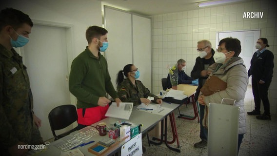 In einem Impfstützpunkt werden eintreffende Impflinge von den Mitarbeitenden begrüßt. © Screenshot 