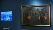 In einem Museum hängen an einer blöauen Wand zwei Gemälde des Mecklenburgischen Künstlers Rudolf Bartels. © Screenshot 