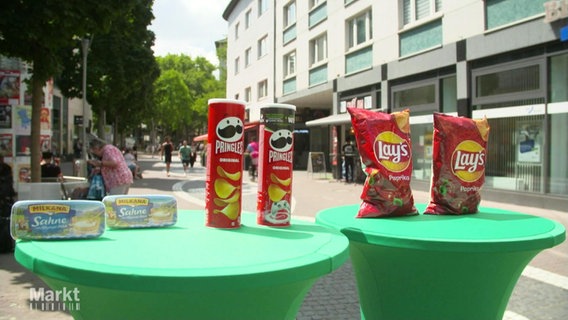 Verschiedene Lebensmittel stehen auf Tischen in einer Fußgängerzone © Screenshot 