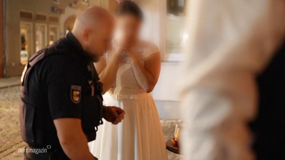 Polizeibeamte stehen rund um eine weinende Frau in einem Hochzeitskleid. © Screenshot 