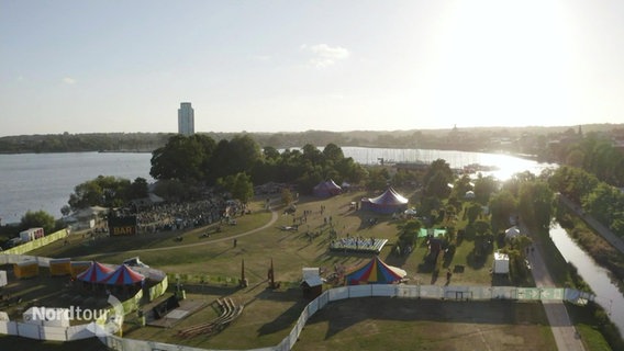 Blick aus der Vogelperspektive auf ein Hafengebiet in dem ein Festivalgelände aufgebaut ist. © Screenshot 