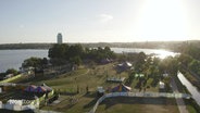 Blick aus der Vogelperspektive auf ein Hafengebiet in dem ein Festivalgelände aufgebaut ist. © Screenshot 