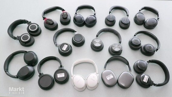 Kopfhörer verschiedener Marken liegen auf einer hellen Oberfläche © Screenshot 