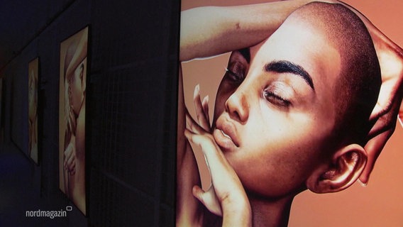 Ein digitales Kunstwerk zeigt eine Frau mit kurzen Haaren, die sich posierend die Hände um den Kopf schlingt. © Screenshot 