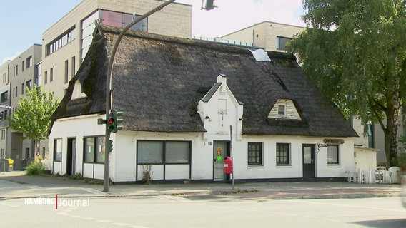 Die denkmalgeschützte Schulkate in Lurup. Ein weiß verputzter Bau mit einem Reetdach. © Screenshot 