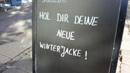 Ein Schild wirbt mit neuen Winterjacken. © Screenshot 