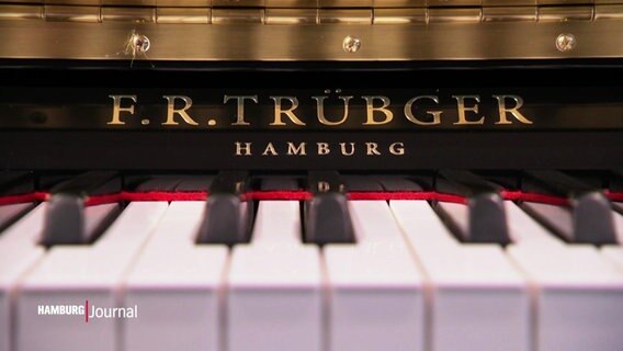 Ein Piano trägt die goldene Aufschrift: "F. R. Trübger Hamburg" © Screenshot 