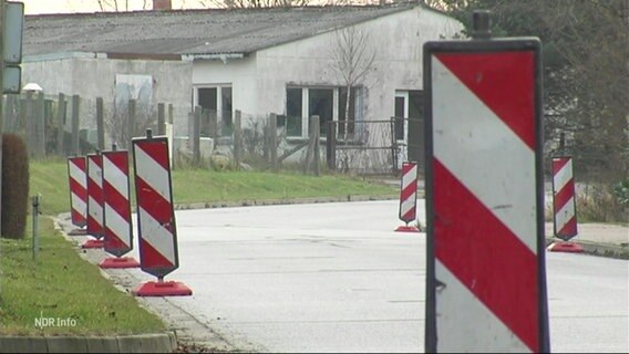 An einer Straße sind rot-weiße Warnschilder aufgestellt. © Screenshot 