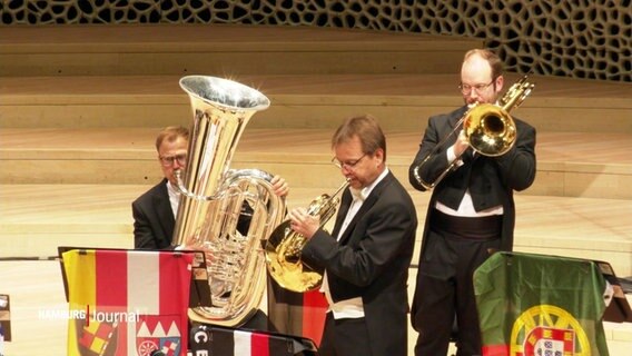 Drei Blasmusiker auf der Bühne der Elbphilharmonie. © Screenshot 