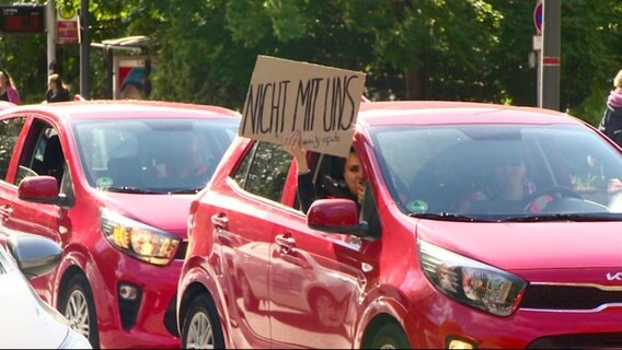 Ein Schild wird aus einem Auto heraus gehalten. © Screenshot 