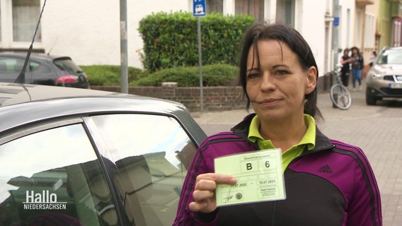 Eine Anwohnerin zeigt ihren Anwohnerparkausweis. © Screenshot 
