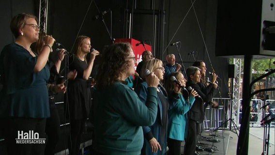 Ein Gospelchor singt auf der Bühne. © Screenshot 