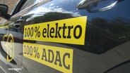 Ein schwarzes Auto mit der Aufschrift "100% Elektro, 100% ADAC". © Screenshot 