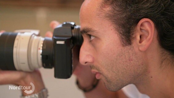 Ballett-Fotograf Kiran West fokussiert mit seiner Kamera ein Fotoobjekt. © Screenshot 