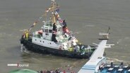 Mit Wimpelketten geschmückter Schlepper. © Screenshot 