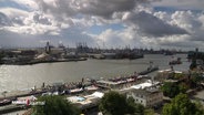 Ein bewölkt-sonniger Himmel zieht über den Hamburger Hafen und die Landungsbrücken hinweg. © Screenshot 