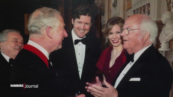 Der Präsident des Anglo-German Clubs Claus Budelmann (re.) begrüßt freudig den damaligen Prince Charles (li.) auf einem älteren Foto. © Screenshot 