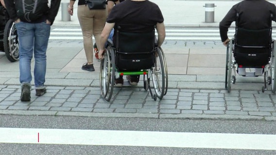 Rollstuhlfahrer neben Fußgängern. © Screenshot 