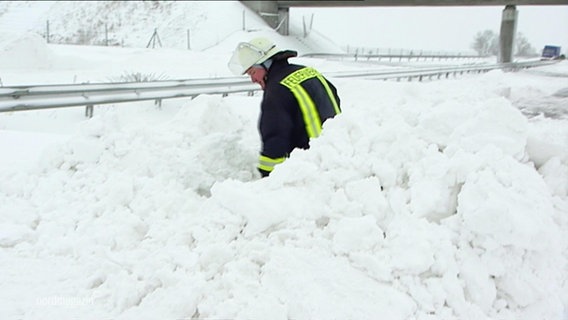 Ein Feuerwehrmann schaufelt Schnee © Screenshot 