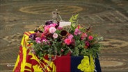 Blick auf den mit bunten Blumengestecken verzierten Sarg der Queen. © Screenshot 
