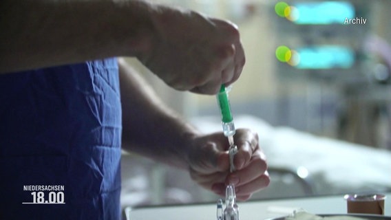 Eine Spritze wird von einem Krankenpfleger vorbereitet © Screenshot 