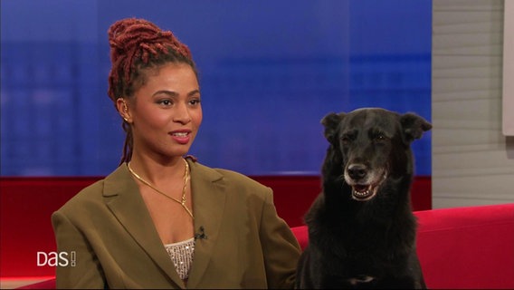 Aysha Joy Samuel mit ihrem Hund Joy auf dem roten Sofa. © Screenshot 