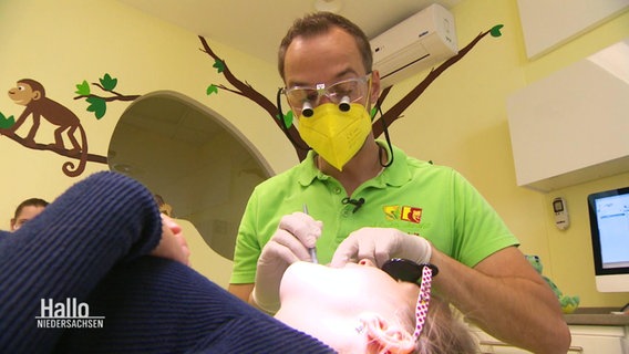 Ein Zahnarzt kontrolliert die Zähne eines Kindes. © Screenshot 