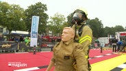 Ein Feuerwehrmann zieht bei den FireFit Championships in Bad Bramstedt eine Übungspuppe. © Screenshot 