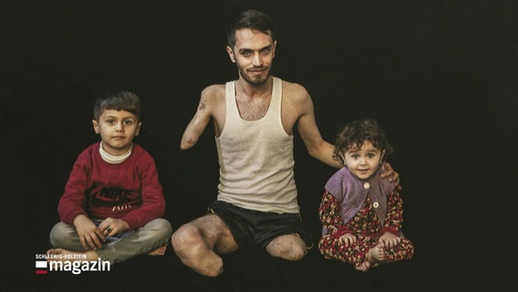 Foto eines kriegsversehrten Vaters mit seinen Kindern im Irak. © Screenshot 