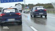 Szene auf der Autobahn mit den beiden Fahrzeugen der Klimaaktivisten und einem Polizeiauto. © Screenshot 
