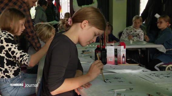 Mehrere malende Kinder an einem Tisch. © Screenshot 