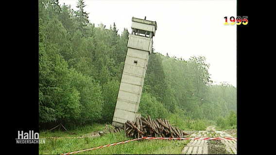 Aufnahme von 1995: Ein grauer Grenzwachturm wird abgerissen und ist gerade am fallen. © Screenshot 
