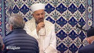 Ein Imam singt ein Gebet in einer Moschee. © Screenshot 