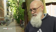 Ein Mann mit langem weißem Bart im Interview. © Screenshot 