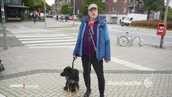 Ein Mann steht mit seinem Hund auf der Straße. © Screenshot 