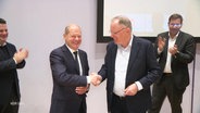 Kanzler Scholz schüttelt dem niedersächsischen Wahlsieger Weil (beide SPD) fröhlich die Hand. © Screenshot 