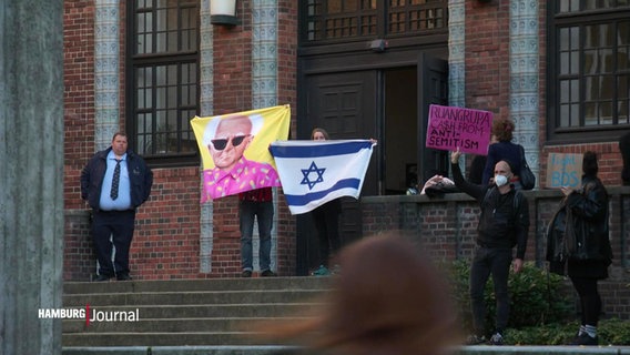 Demonstranten mit einer israelischen Flagge auf Treppenstufen. © Screenshot 