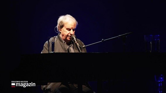 Sänger Chris de Burgh sitzt bei einer Probe im Scheinwerferlicht am Klavier. © Screenshot 