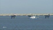 Ein Schiff der Wasserschutzpolizei patrouilliert an der LNG-Leitung in Wilhelmshaven. © Screenshot 