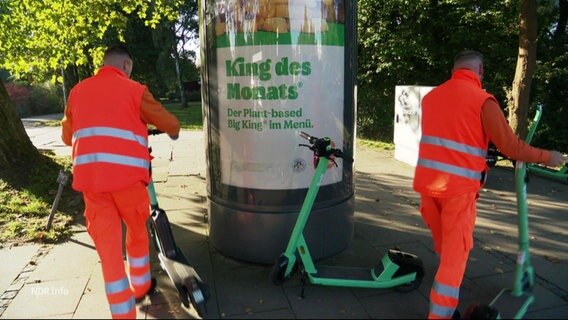 Angestellte der Stadtreinigung räumen E-Roller aus dem Weg. © Screenshot 