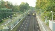 Zwei Bagger sind auf zwei nebeneinander gelegenen Bahngleisen unterwegs. © Screenshot 