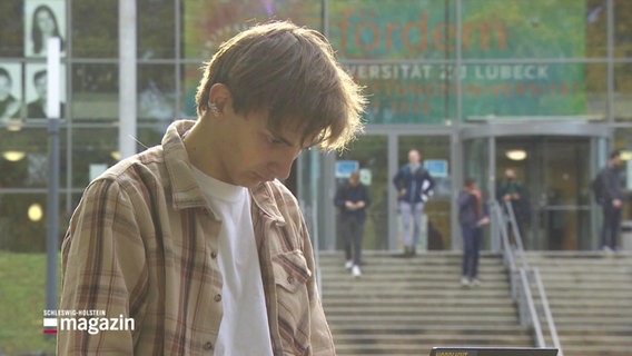 Nahaufnahme eines Studenten vor der Universität Lübeck. © Screenshot 