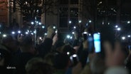 Protestierende benutzen ihre Smartphones als Lichter im Dunkeln. © Screenshot 