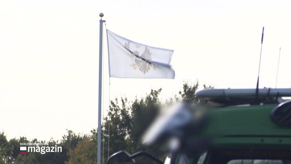 Weiße Flagge mit schwarzem Adler. © Screenshot 