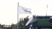 Weiße Flagge mit schwarzem Adler. © Screenshot 