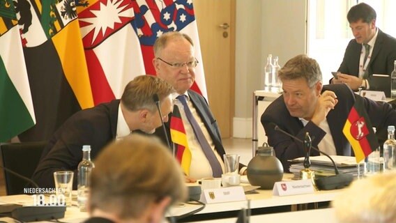 Bundeswirtschaftsminister Robert Habeck und Bundesfinanzminister Christian Lindner beugen sich vor dem niedersächsischen Ministerpräsidenten Stephan Weil zueinander, um etwas zu besprechen. © Screenshot 