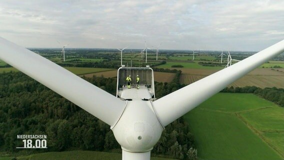 Blick aus der Vogelperspektive auf den kopf eines Windrads, auf dem sich zwei Arbeitende befinden. © Screenshot 