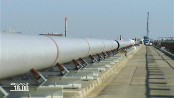 Auf einem Hafengelände erstreckt sich eine lange Pipeline für Flüssiggas (LNG). © Screenshot 